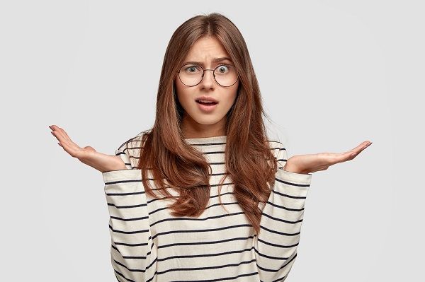 Woman with her arms raised indicating doubt about what Argan oil is