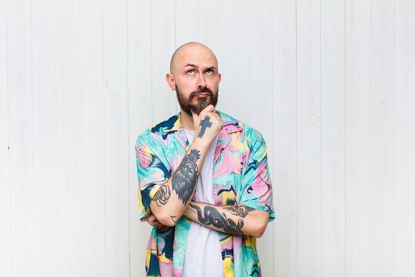 Bald man thinking looking up wearing typical summer shirt