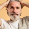 Man touching his hair with white roots